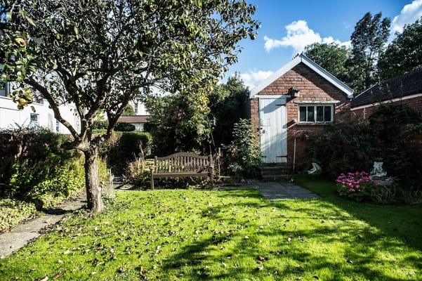 Well-maintained garden with a bench and trees
