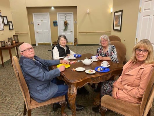 Residents enjoying tea and snacks at a communal table