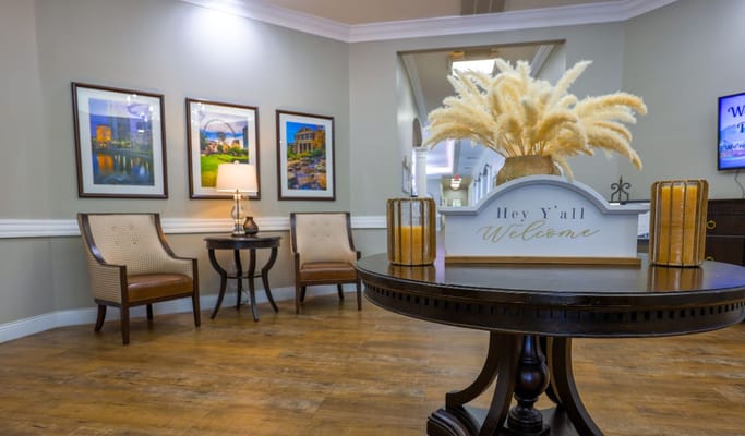 Cozy lobby with seating, welcome sign, and decorative plants