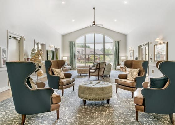 Comfortable seating area in a well-lit living room with large windows.