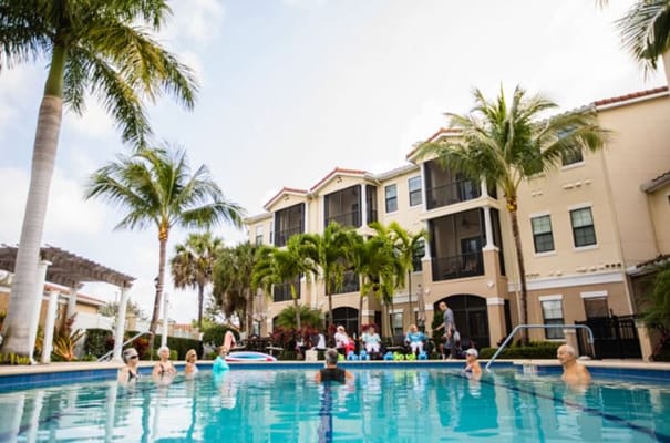 Seniors enjoying a sunny day by the pool at Addington Place of Jupiter