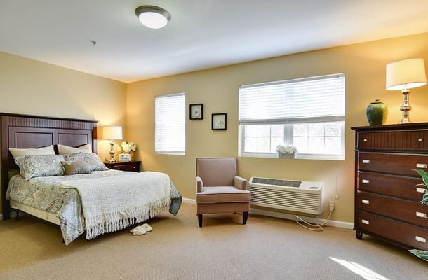 Bright and inviting bedroom with a bed, chair, and dresser