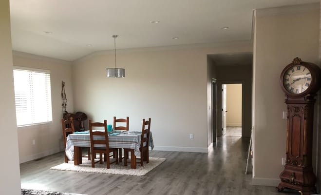 Bright interior of a dining area with wooden table and clock