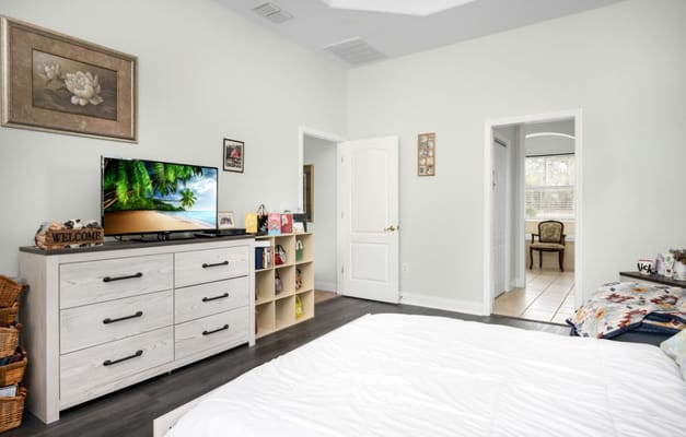 Brightly lit resident room with a dresser and TV