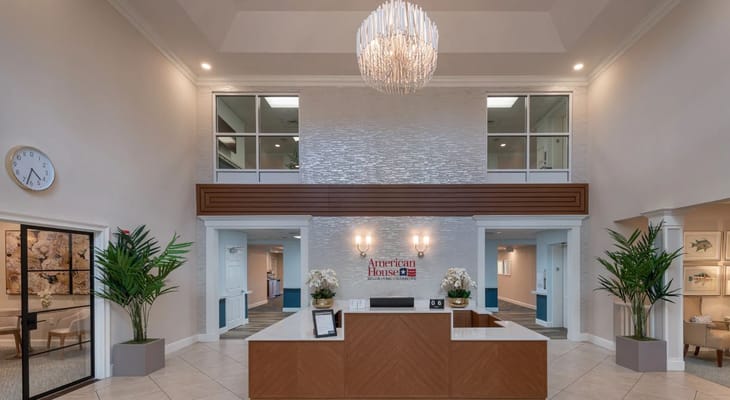 Bright lobby area with reception desk and chandelier