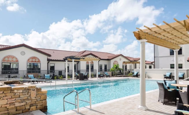 Outdoor pool area with seating and cabana