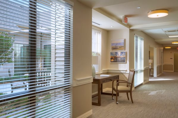 Well-lit interior hallway with windows and decor