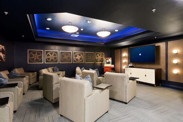 Common area lounge with comfortable seating and a screen