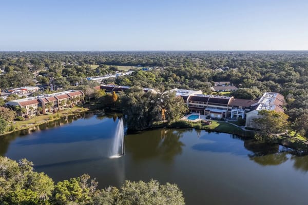 Aerial view of a senior living facility by a pond