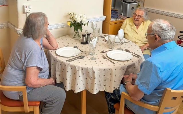 Residents enjoying a meal together at a dining table
