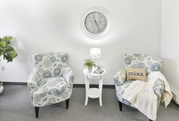 Cozy seating area with decorative chairs and a clock