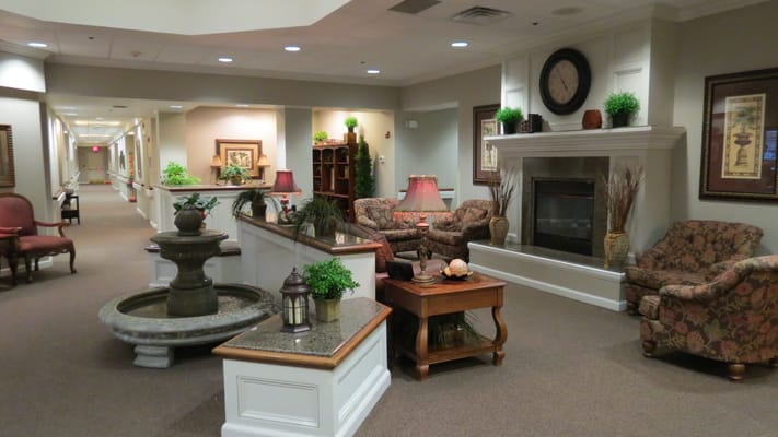 A cozy living room area with a fountain, seating, and decorative lamps.