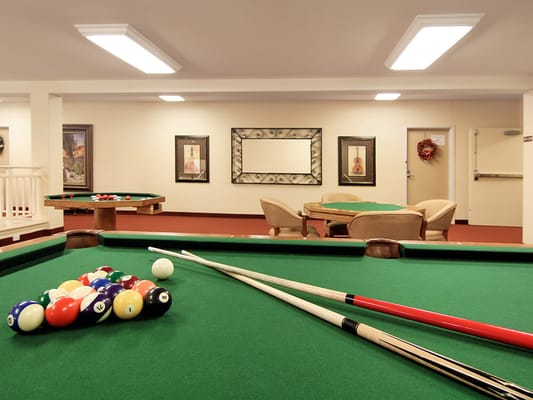 Interior activity room with billiard tables and seating