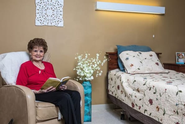 An elderly woman reading in her cozy room