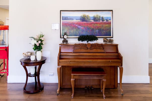 Interior view of a lobby area with a piano and artwork