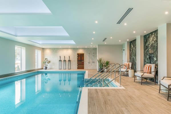 Indoor swimming pool with natural light and seating