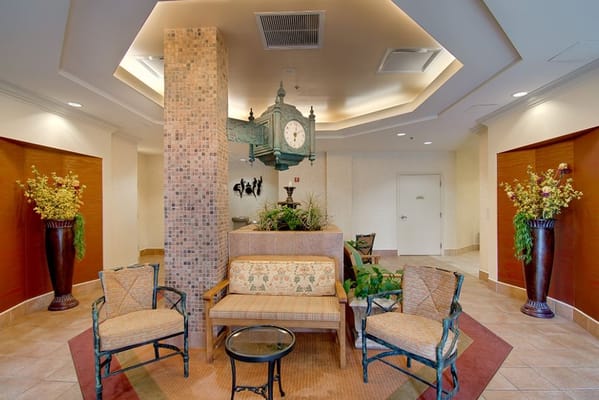 Cozy lobby with plants, a clock, and seating area