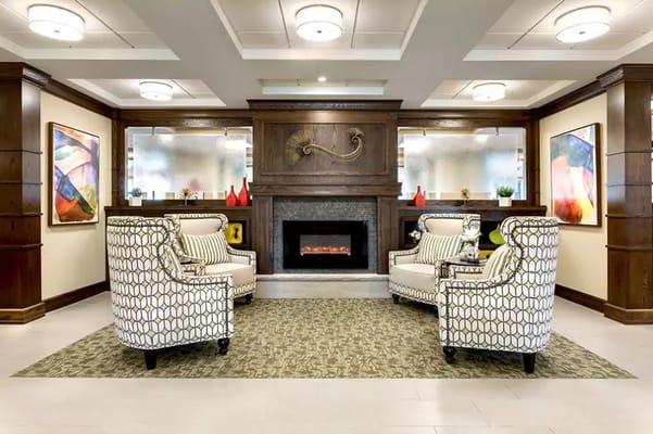 Cozy lobby with two patterned armchairs facing a fireplace