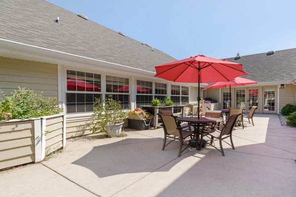 Outdoor patio area with tables and red umbrellas