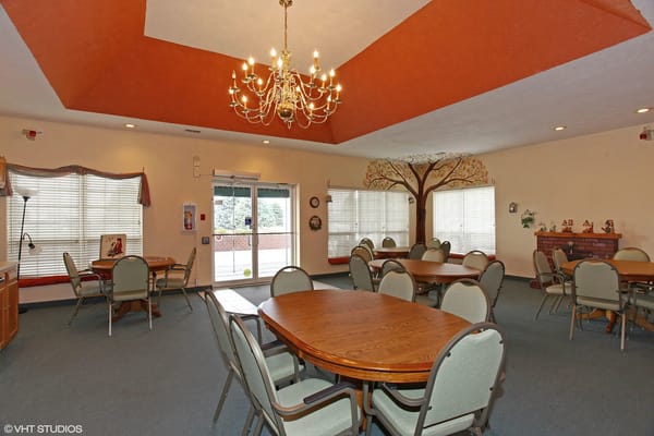 Bright common area with dining tables and tree mural