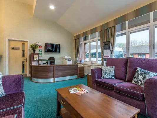 Cozy lobby seating area with a reception desk and large windows