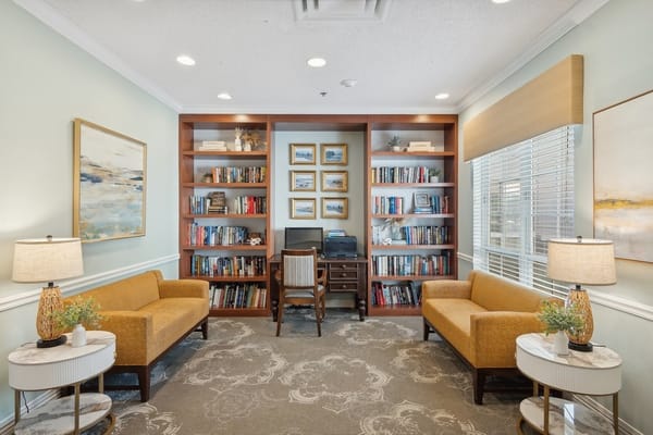 A cozy reading room with bookshelves, seating, and decor.