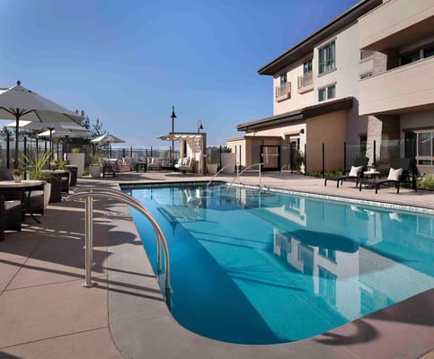 Swimming pool area with lounge chairs and umbrellas