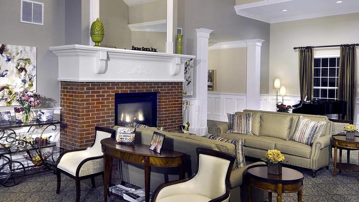Stylish living room with fireplace and seating area at Belmont Village.