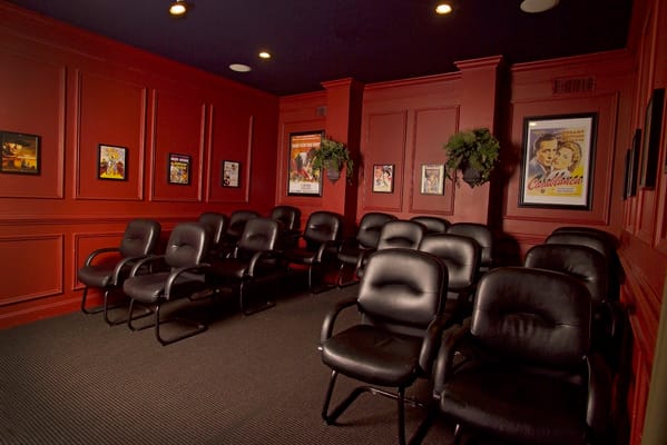 Cozy movie theater room with black chairs and red walls