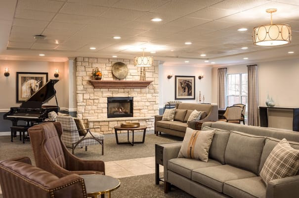 A stylish living room with a stone fireplace and piano.