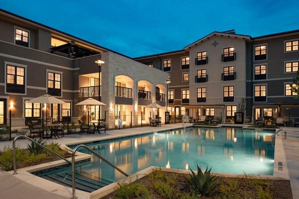 Exterior view of the facility with pool area at dusk.