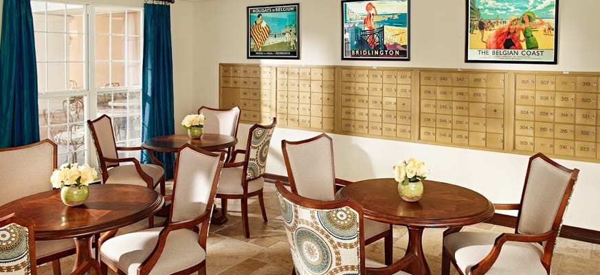 Bright common area with tables and artwork on the walls