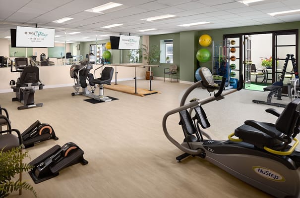 A fitness area with exercise equipment and wooden barre