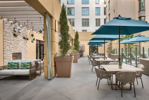 A spacious patio with seating and umbrellas at Belmont Village Senior Living Westwood