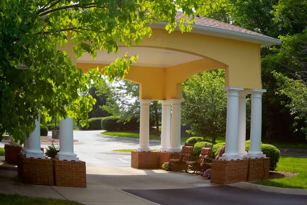Covered entrance with rocking chairs and greenery