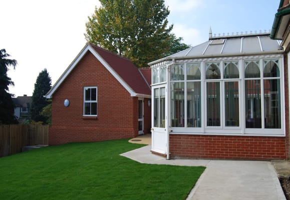 Exterior view of a facility with a conservatory and green lawn