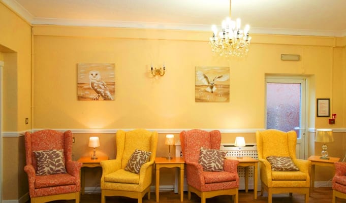 Cozy common area with yellow chairs and art on the walls