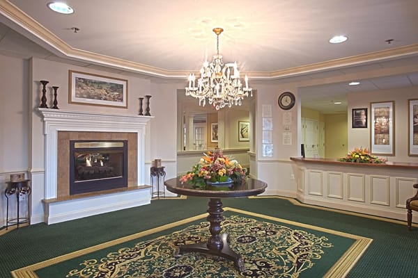 Bright lobby area with a chandelier and floral arrangement