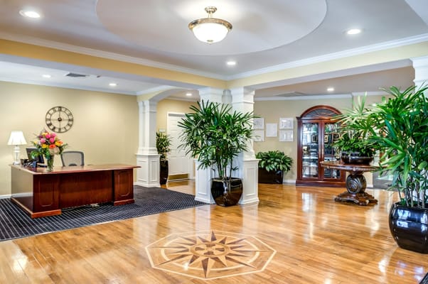 Bright lobby area with a reception desk and indoor plants