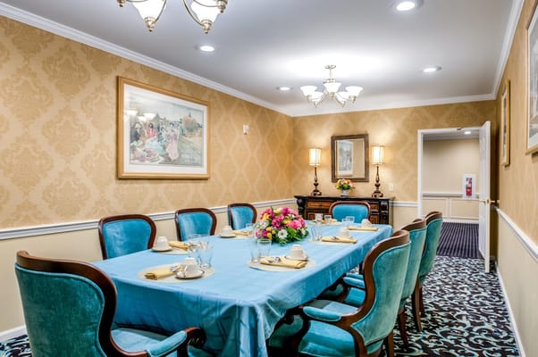 Well-decorated dining room with blue tablecloth and floral centerpiece.