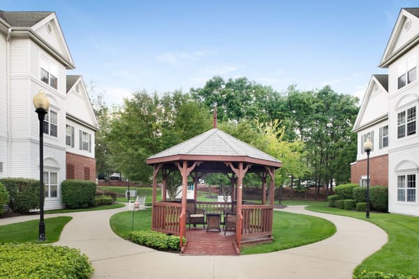 Outdoor gazebo surrounded by landscaped paths and trees