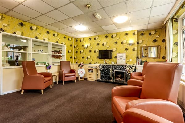 Lounge area with comfortable chairs and floral wallpaper