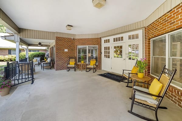 Outdoor seating area with yellow chairs and flowers