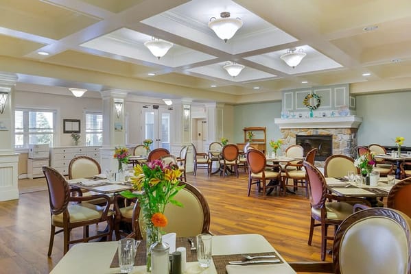 Bright dining area with floral centerpieces and wooden flooring