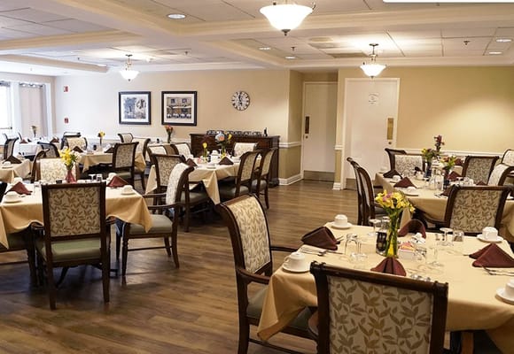 Dining room with neatly set tables and floral centerpieces