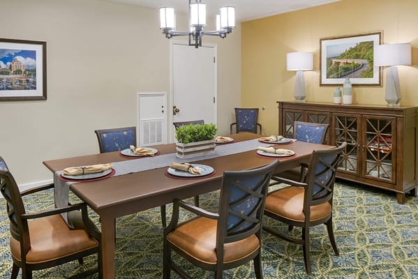 A dining room setup with a large table and chairs
