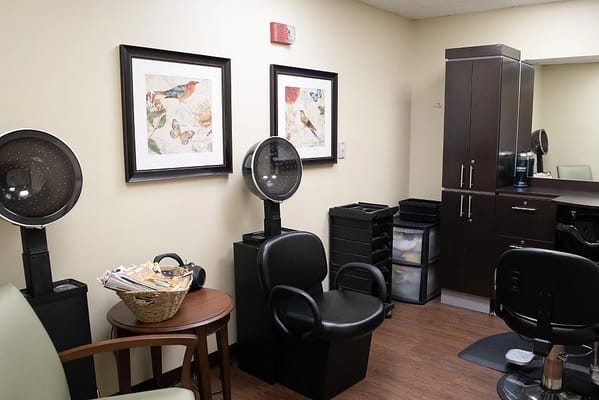 Interior of a salon area with styling chairs and artwork on the walls