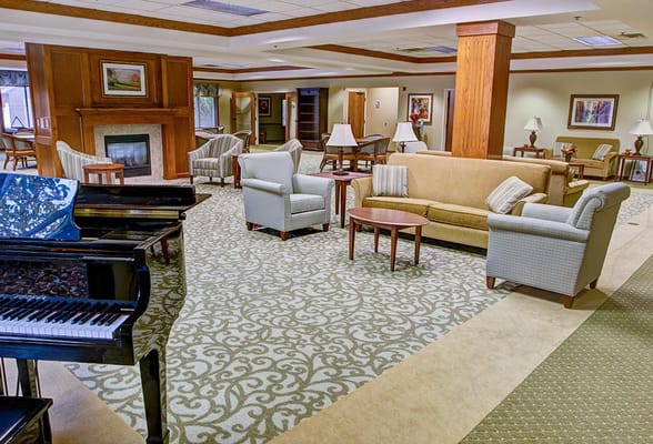 Bright common area with seating and a piano
