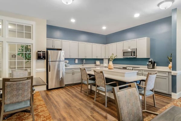 Modern kitchen area with dining tables and appliances