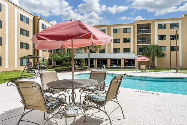 Outdoor pool area with seating and umbrellas